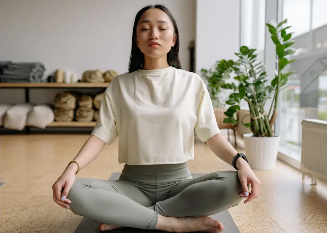 Ragazza seduta in una sala meditazione durante un momento di benessere psicofisico