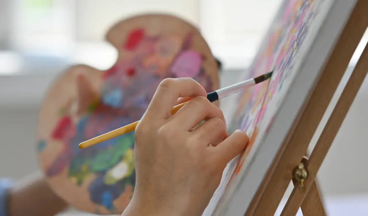 Artista dipinge su una tela, simbolo di vocazione e talento nei film sul lavoro